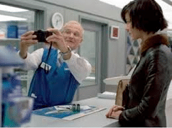 Man Inspects Camera Technology and Getting Photos Developed